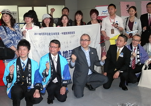 成田空港に到着した中国からの団体ツアー客と、出迎えた溝畑長官ら日本の観光関係者（20日）