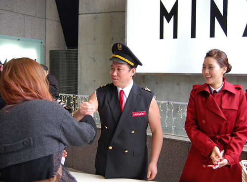 スギちゃんが通行人にイースター航空グッズを配布して搭乗を呼びかけた