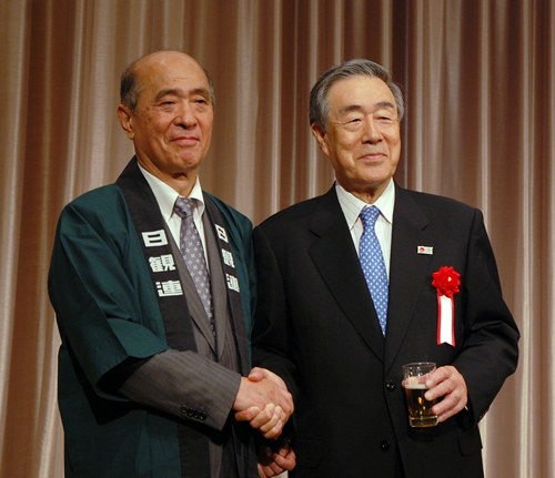 日観連の懇親会で握手する近兼会長(左)と佐藤会長