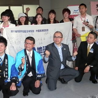 成田空港に到着した中国からの団体ツアー客と、出迎えた溝畑長官ら日本の観光関係者(20日)
