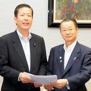 河村官房長官(右)に申込書を渡す公明党の山口政調会長