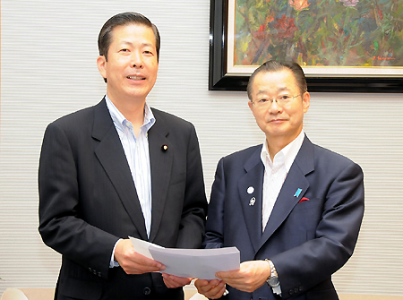 河村官房長官(右)に申込書を渡す公明党の山口政調会長