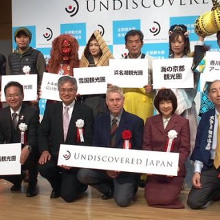 会見後フォトセッションに臨む関係者(前列左端が小林会長)