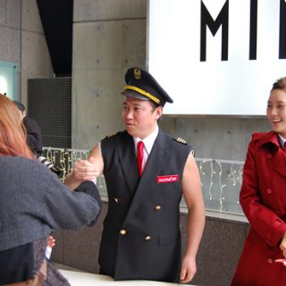 スギちゃんが通行人にイースター航空グッズを配布して搭乗を呼びかけた
