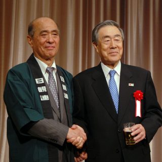 日観連の懇親会で握手する近兼会長(左)と佐藤会長