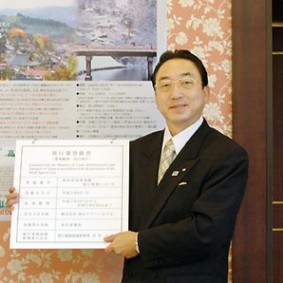 第2種旅行業登録票を持つ新谷社長