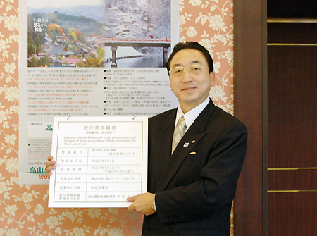 第2種旅行業登録票を持つ新谷社長